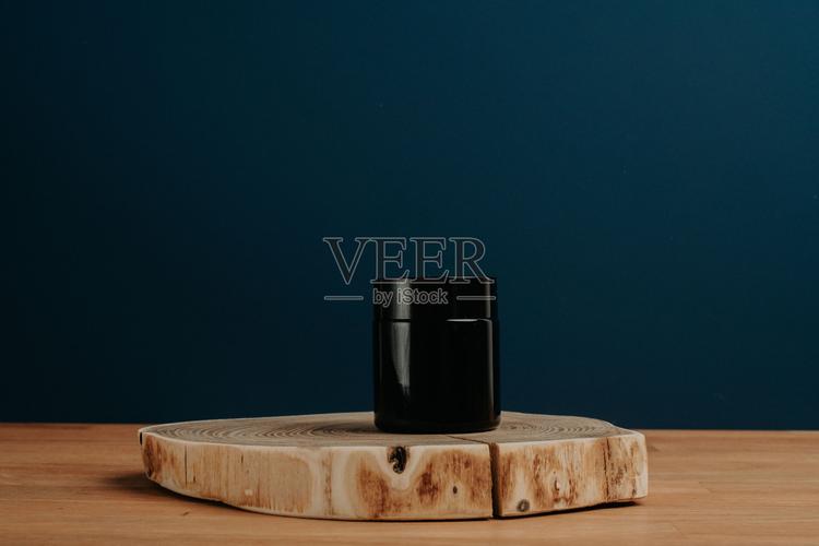 护肤产品的容器放在砍好的原木上的特写镜头作为美丽的背景照片摄影